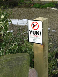 yuk dog fouling sign on post in a park