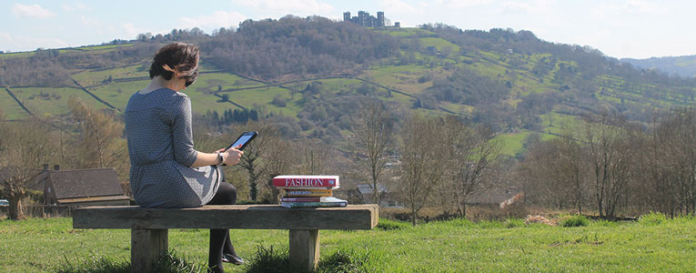 Woman reading a book overlooking Riber Castle